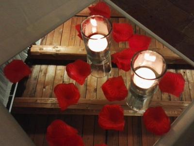 Candele e petali rossi su specchio, atmosfera romantica.