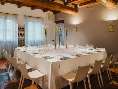 Sala da pranzo elegante con tavolo apparecchiato e decorazioni floreali.