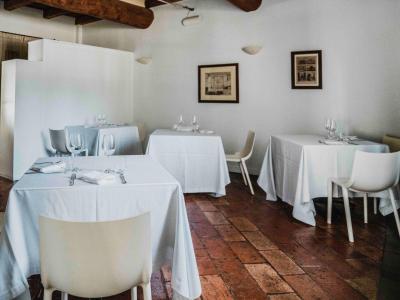 Ristorante elegante con tavoli apparecchiati e sedie bianche.