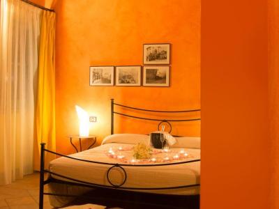 Camera accogliente con pareti arancioni e letto decorato con candele.