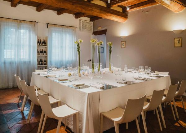 Sala da pranzo elegante con tavolo apparecchiato e decorazioni floreali.